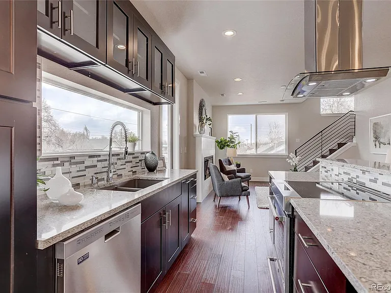 Modern kitchen featuring dark wood cabinets and granite counters with built-in cooktop