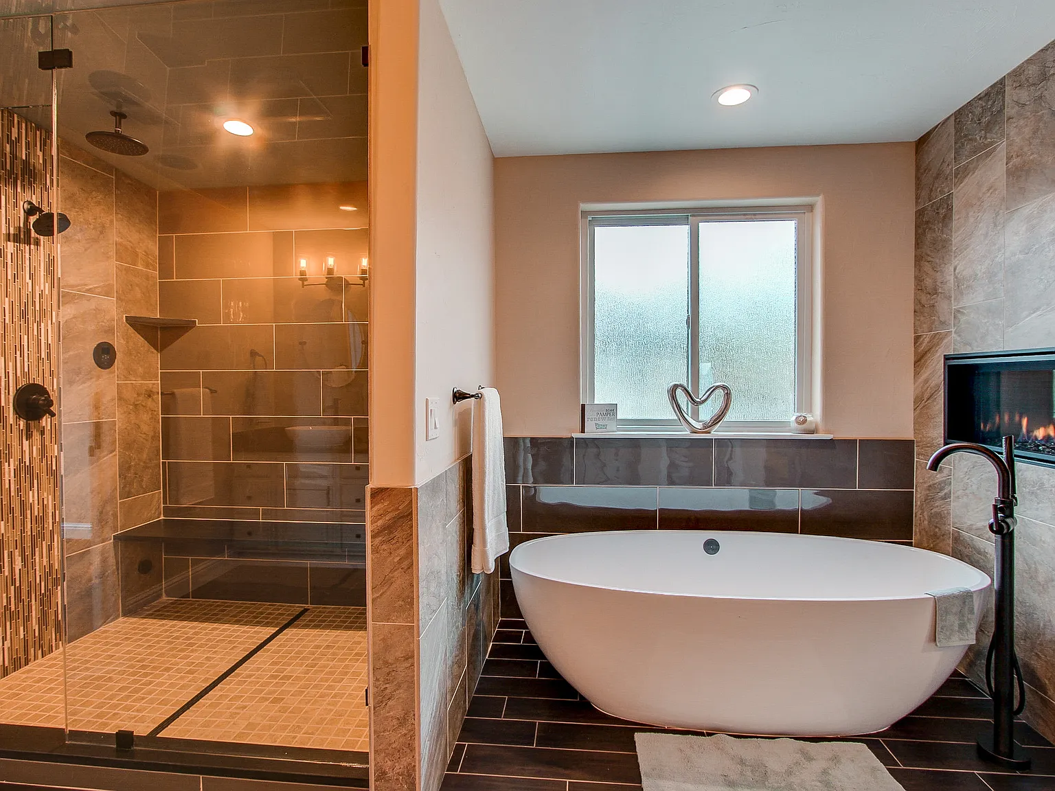 Luxury bathroom featuring a freestanding soaking tub next to a walk-in tile shower with glass doors