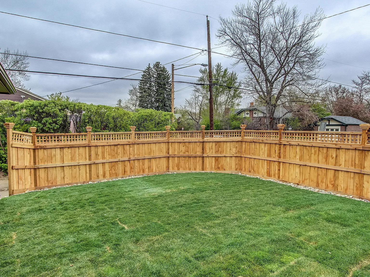 Spacious fenced backyard with fresh sod, privacy fencing, and mature trees—ideal for families or pets