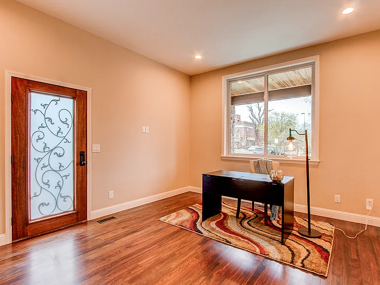 Bright front entryway with custom glass door, hardwood floors, and large bay window in Denver home remodel