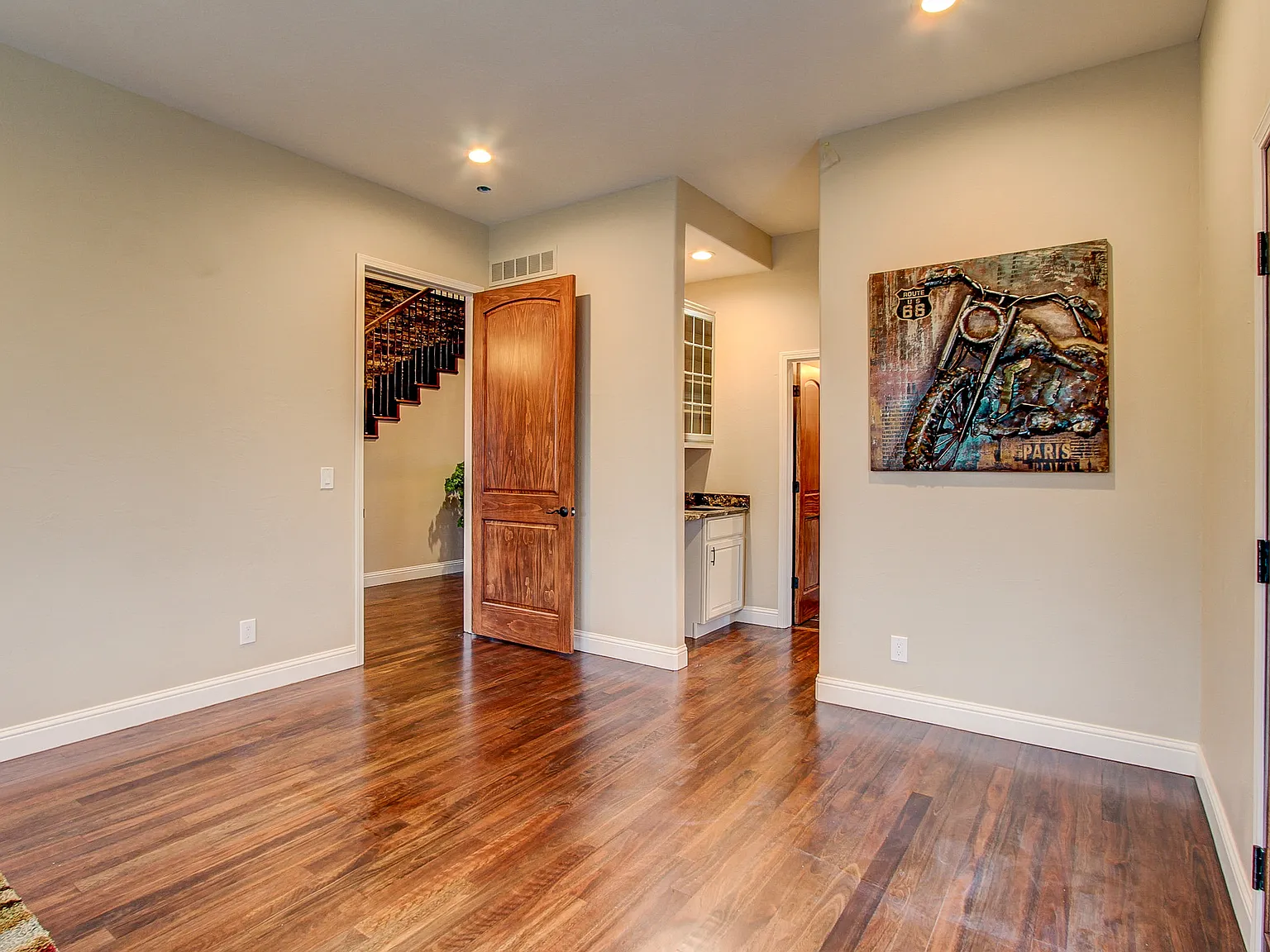 Open-concept hallway and stairway featuring polished hardwood floors and modern lighting accents