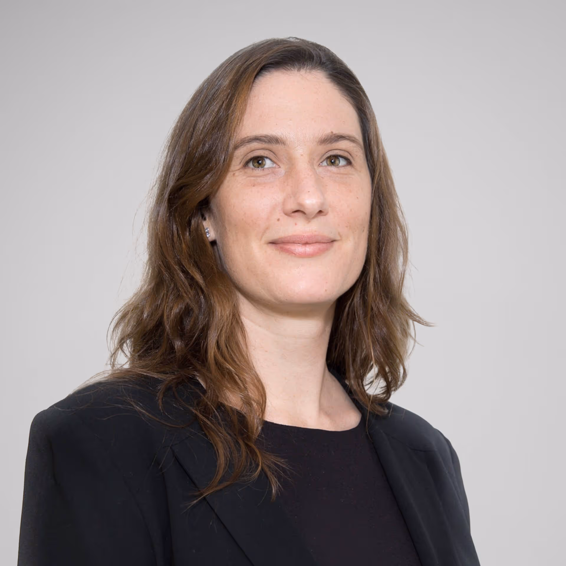 slightly smiling woman in a black blazer