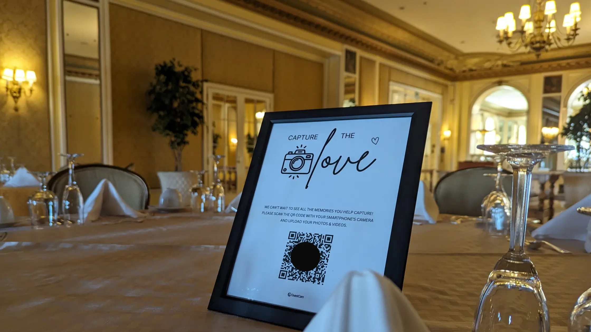 A QR Code sign on a wedding reception table to gather photos