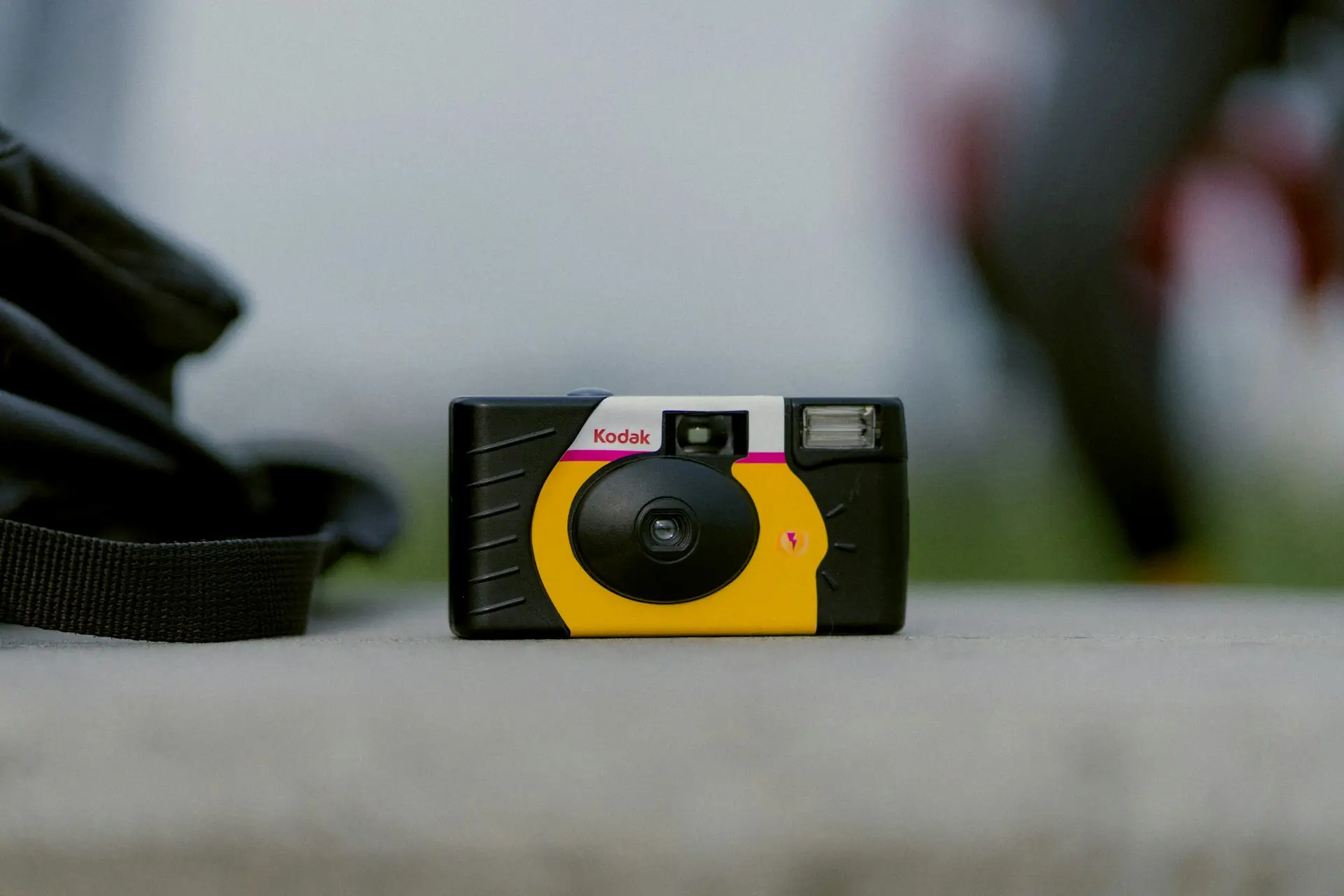 Single-use Kodak disposable camera sitting on a gray stone surface.