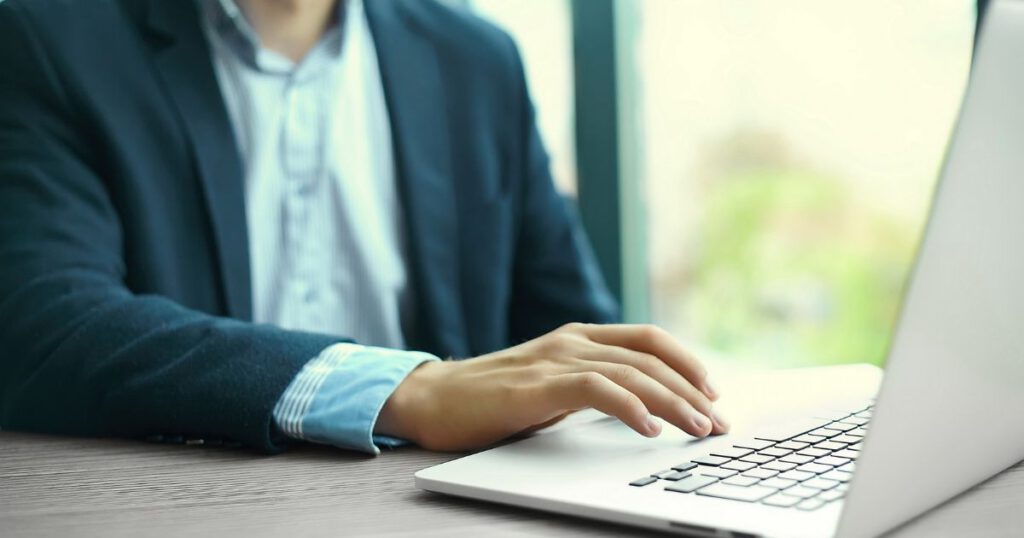 A business professional working on a laptop in a bright office setting, highlighting expert PPC Management Services Orlando.