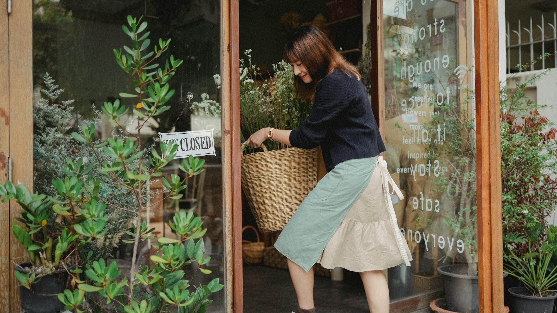 Florist taking flowers into shop