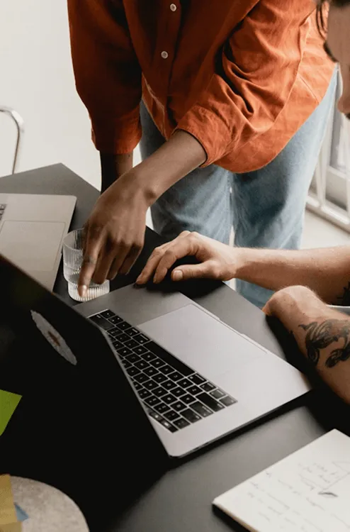 two people looking at a laptop device 
