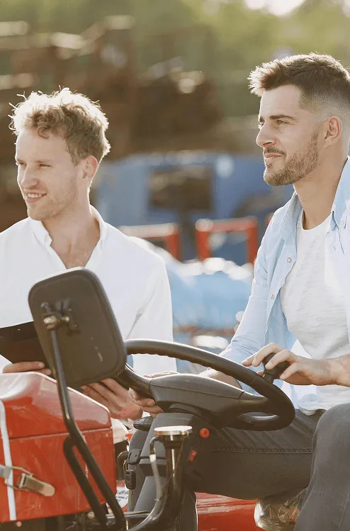 Image of two man riding a farming vehicle