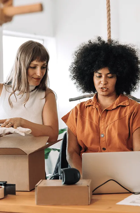 Image of two women looking on a laptop 