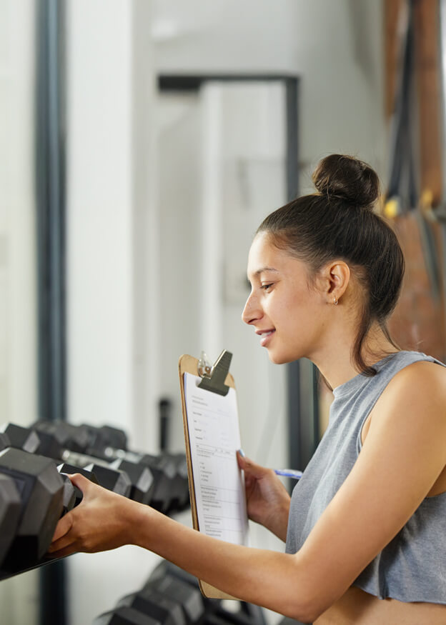 Woman inspecting gym equipment