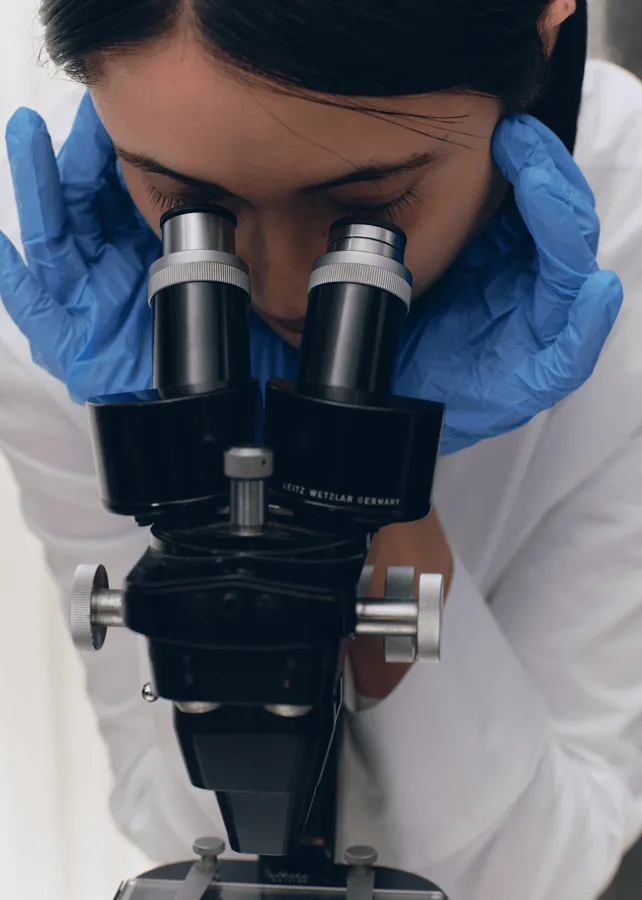 Scientist looking into a microscrope