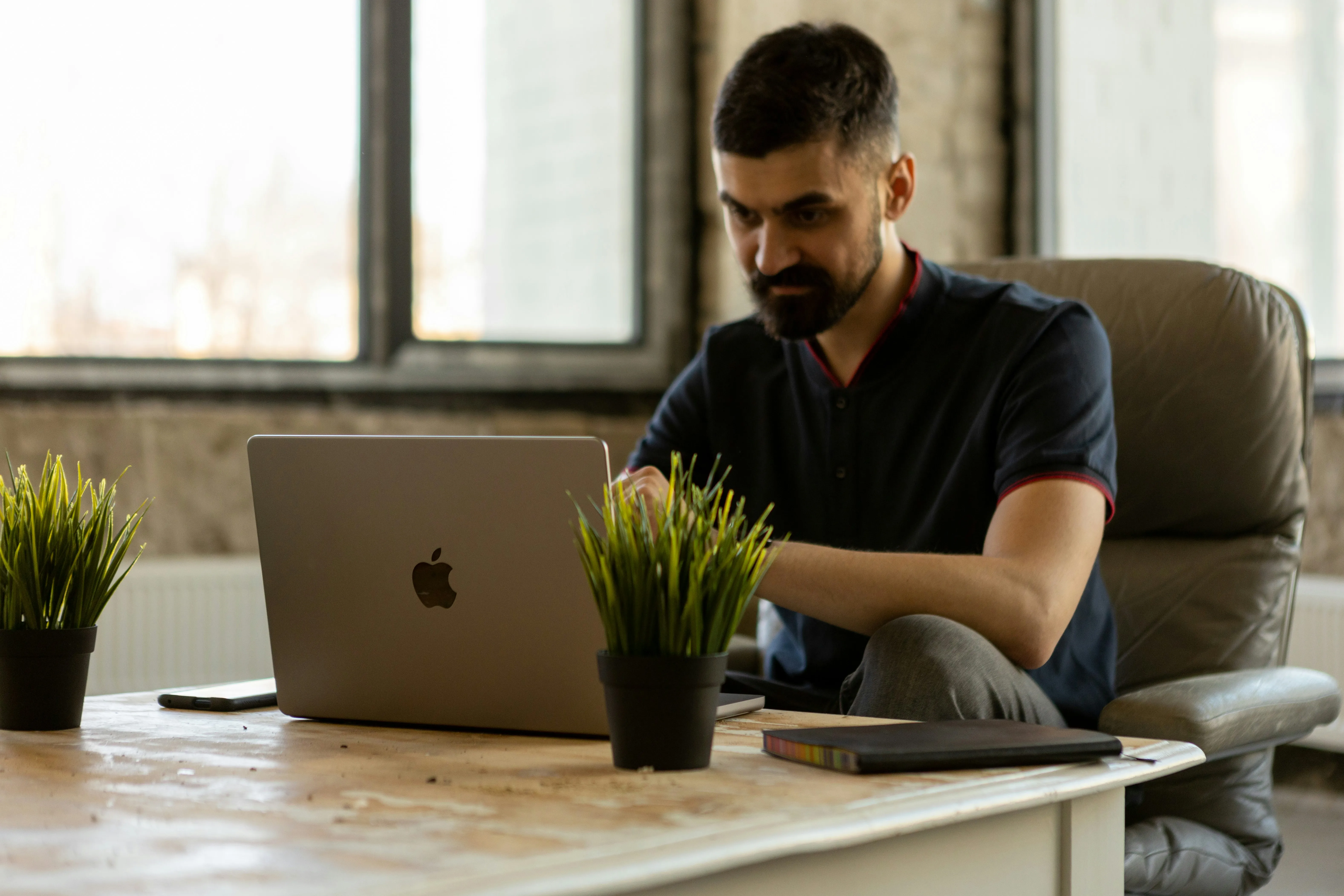 A man sitting at a desk using a laptop