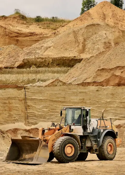 Heavy machinery loader in a sandy excavation site, showcasing essential construction equipment relevant for financing through heavy machinery loans.