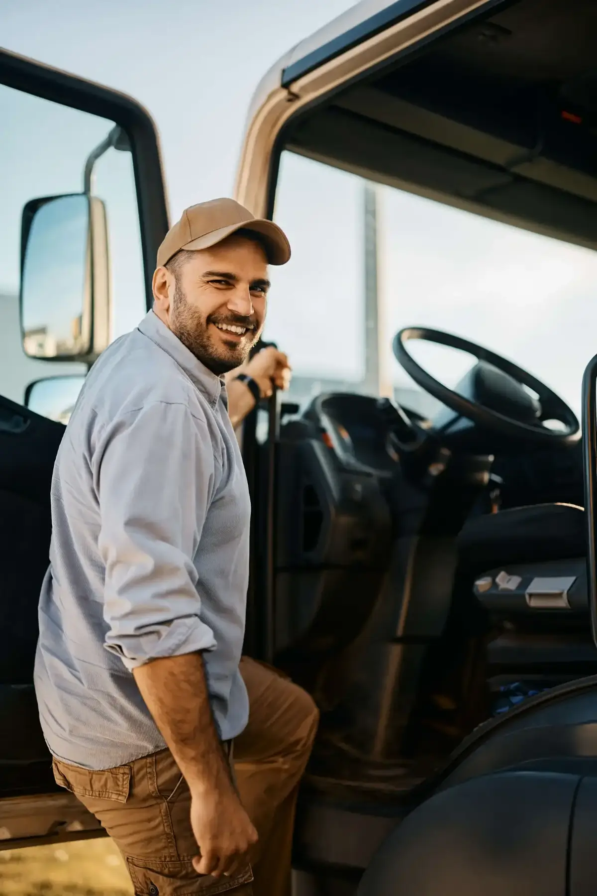 Man smiling while stepping into a commercial vehicle, representing the importance of equipment financing for small businesses.