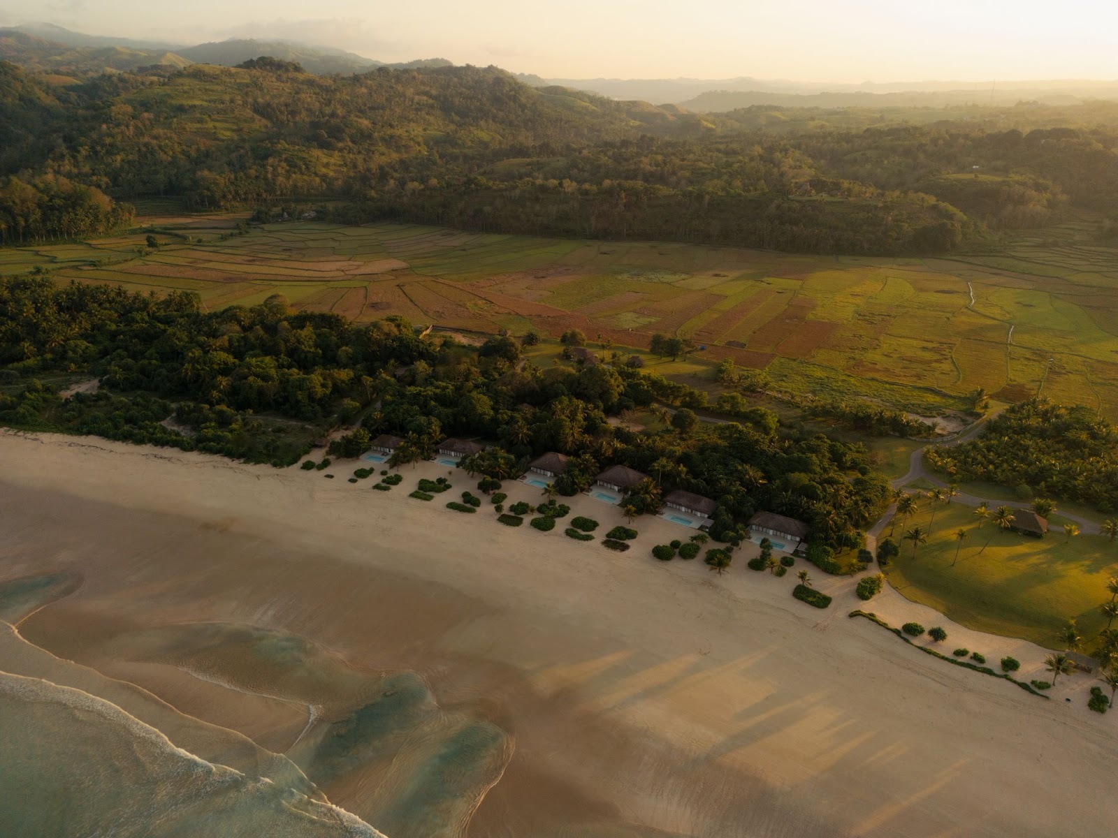 Aerial view of The Sanubari beachfront villas set between pristine shoreline and lush West Sumba landscape.