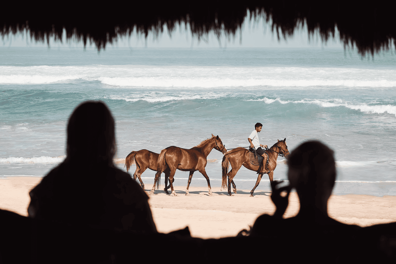 A man rides a horse on a beach in Sumba