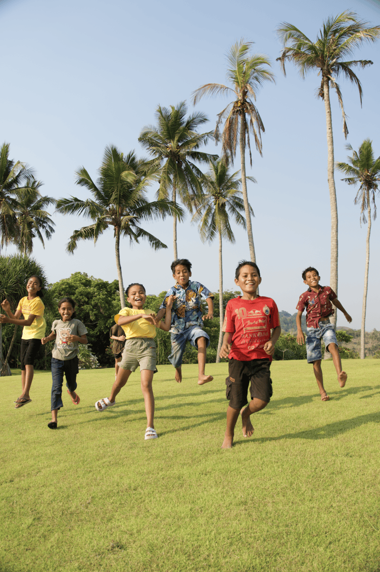 Children playing outdoors in West Sumba highlighting improved wellbeing through community development and sustainable travel initiatives