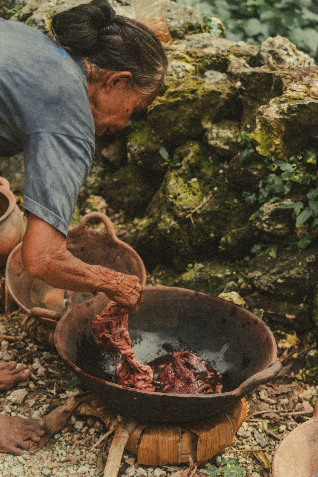 Local artisan dyeing fabric using natural plant-based pigments in West Sumba as part of traditional textile production