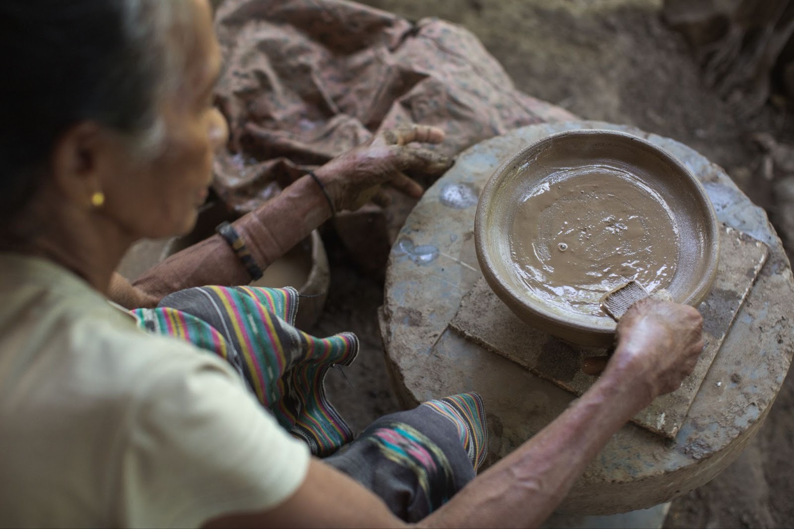 Local artisan in West Sumba shaping clay pottery using traditional techniques reflecting daily life and cultural heritage