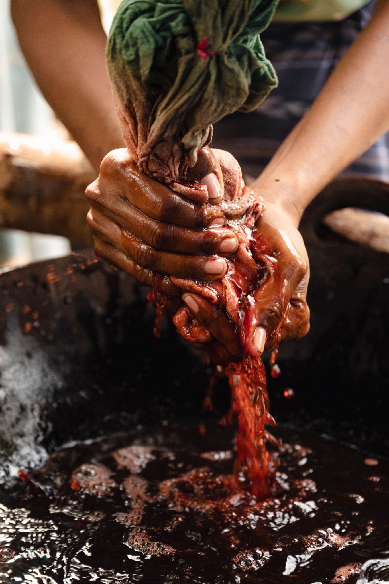 Sumbanese artisan hand-dyeing ikat cotton yarn using natural plant dye in West Sumba Indonesia — traditional ikat weaving process at The Sanubari Sumba