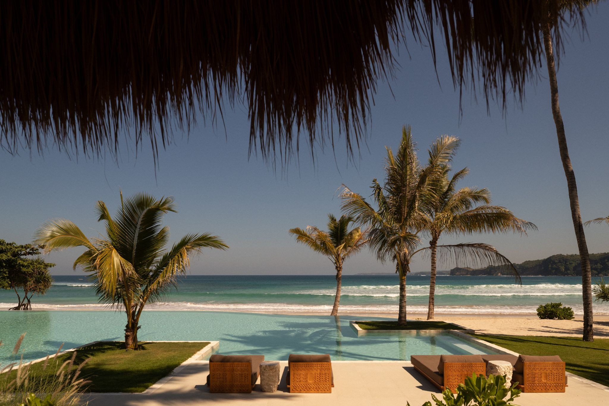 Beachfront infinity pool and dining area overlooking the Indian Ocean at The Sanubari, an exclusive luxury Sumba Island hotel in West Sumba.