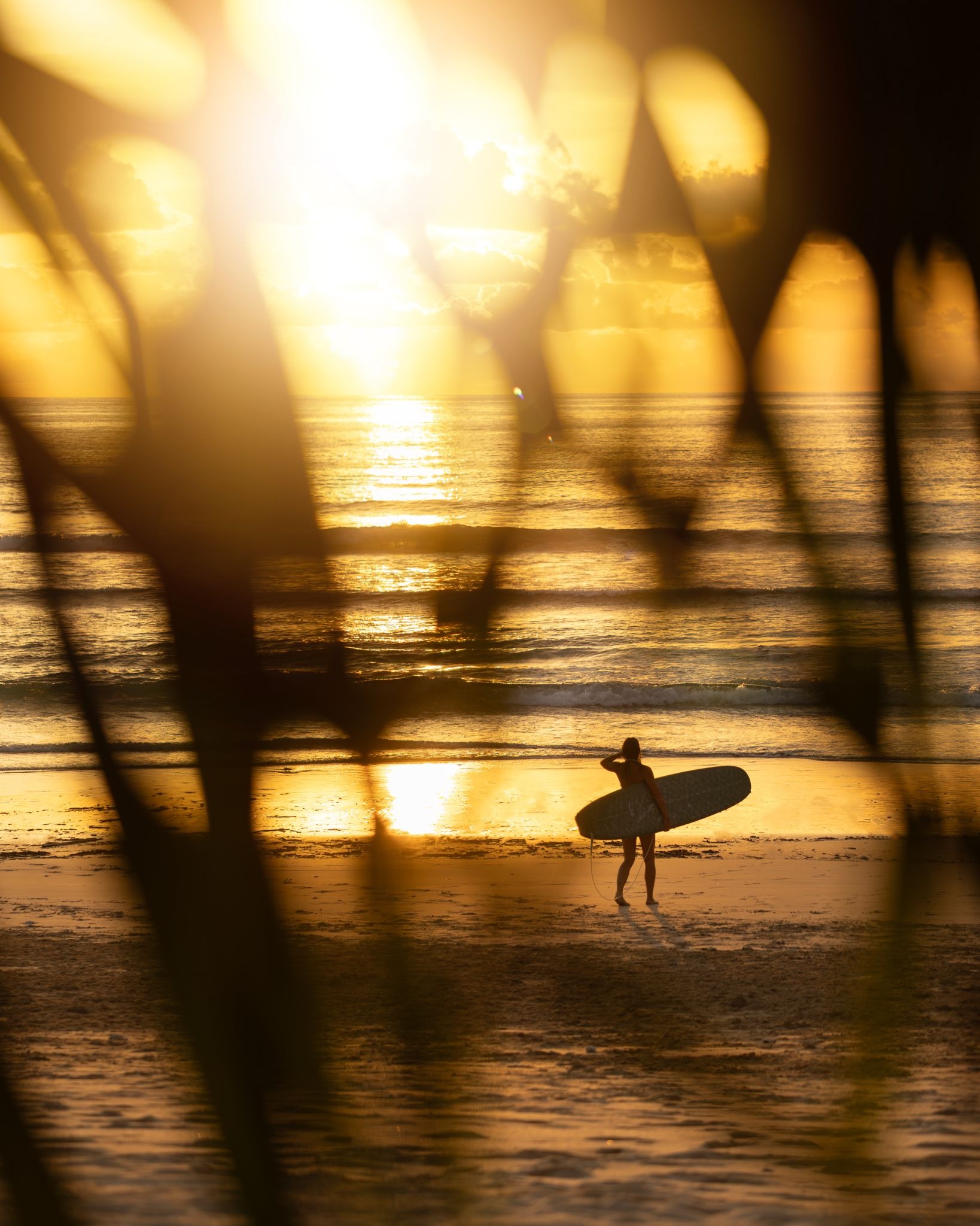 Surfer at golden hour on Dassang Beach at The Sanubari Sumba island hotel West Sumba Indonesia