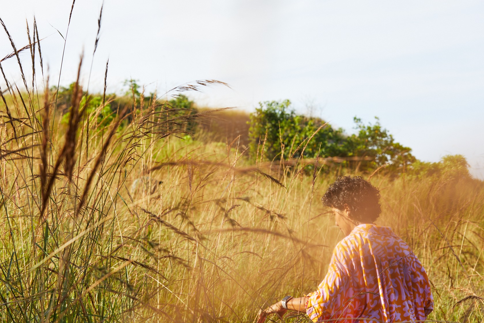 Guest hiking through Sumba's savannah landscape near The Sanubari, exploring nature trails during a stay at a luxury Sumba Island hotel.