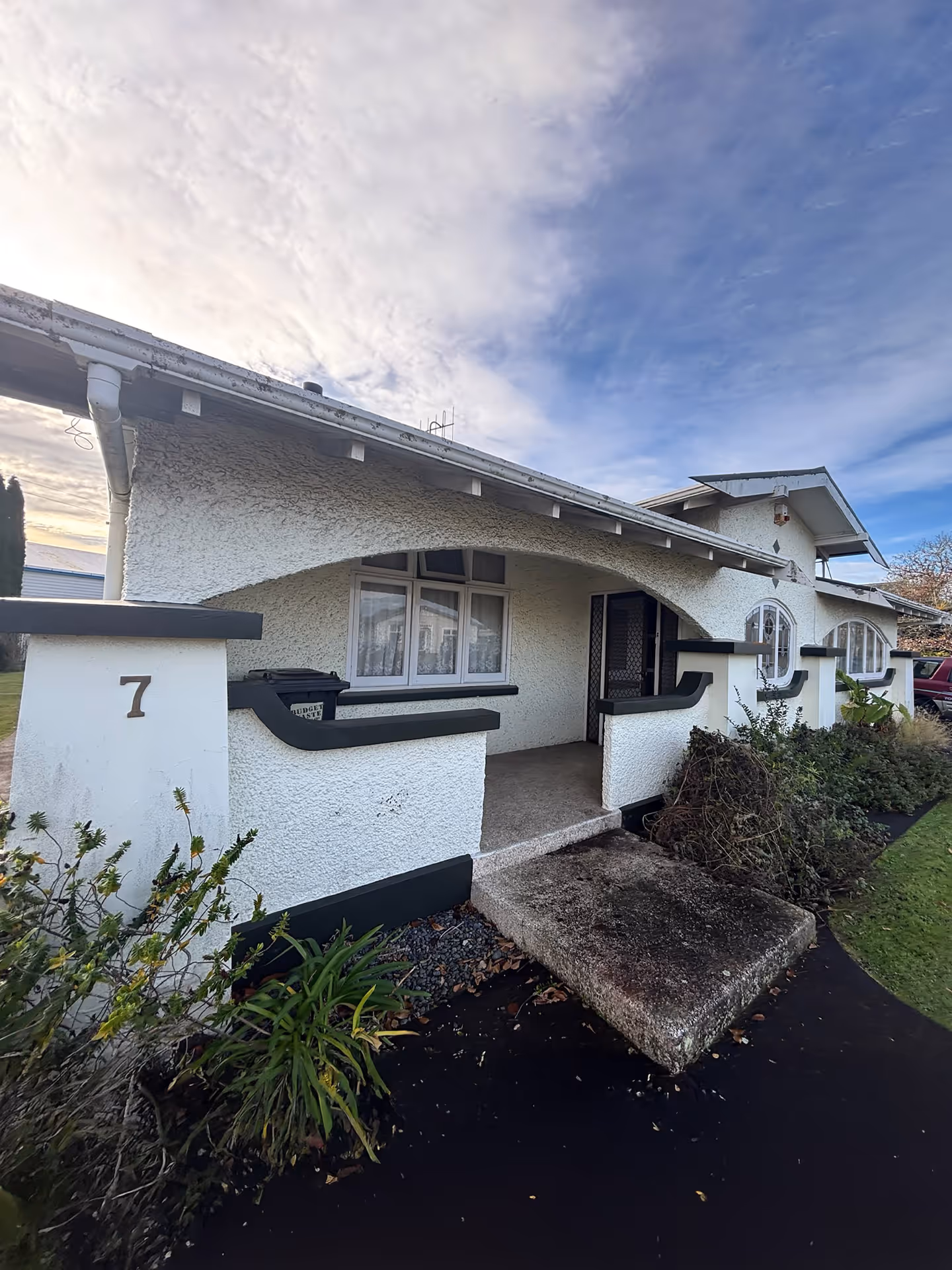 Stucco home with weathered exterior and faded timber windows before repainting by Rivercity Painting Ltd