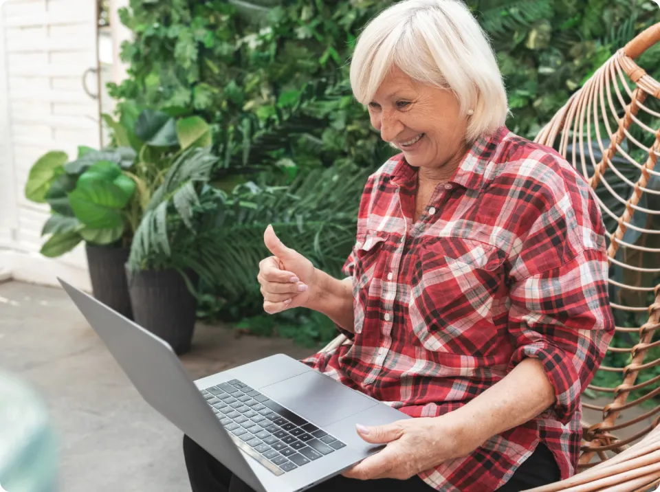A woman sitting in a chair using a laptop computer.