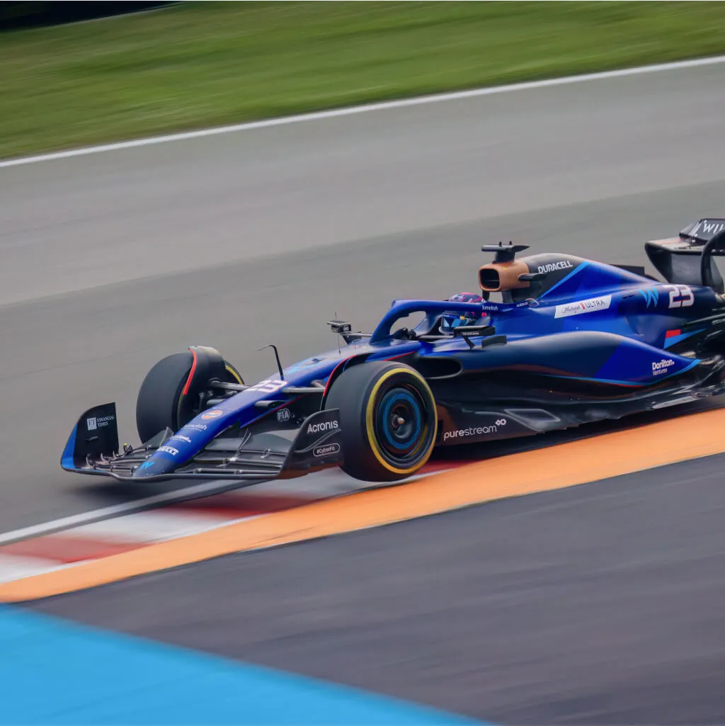 Formula 1 car at speed on track, representing Shape's motorsport work