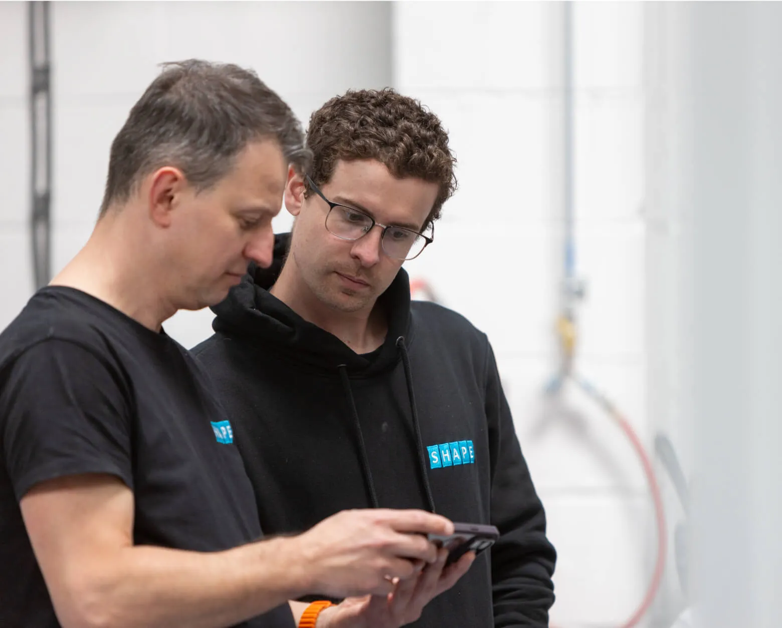 Two members of the Shape team reviewing job information on the shop floor