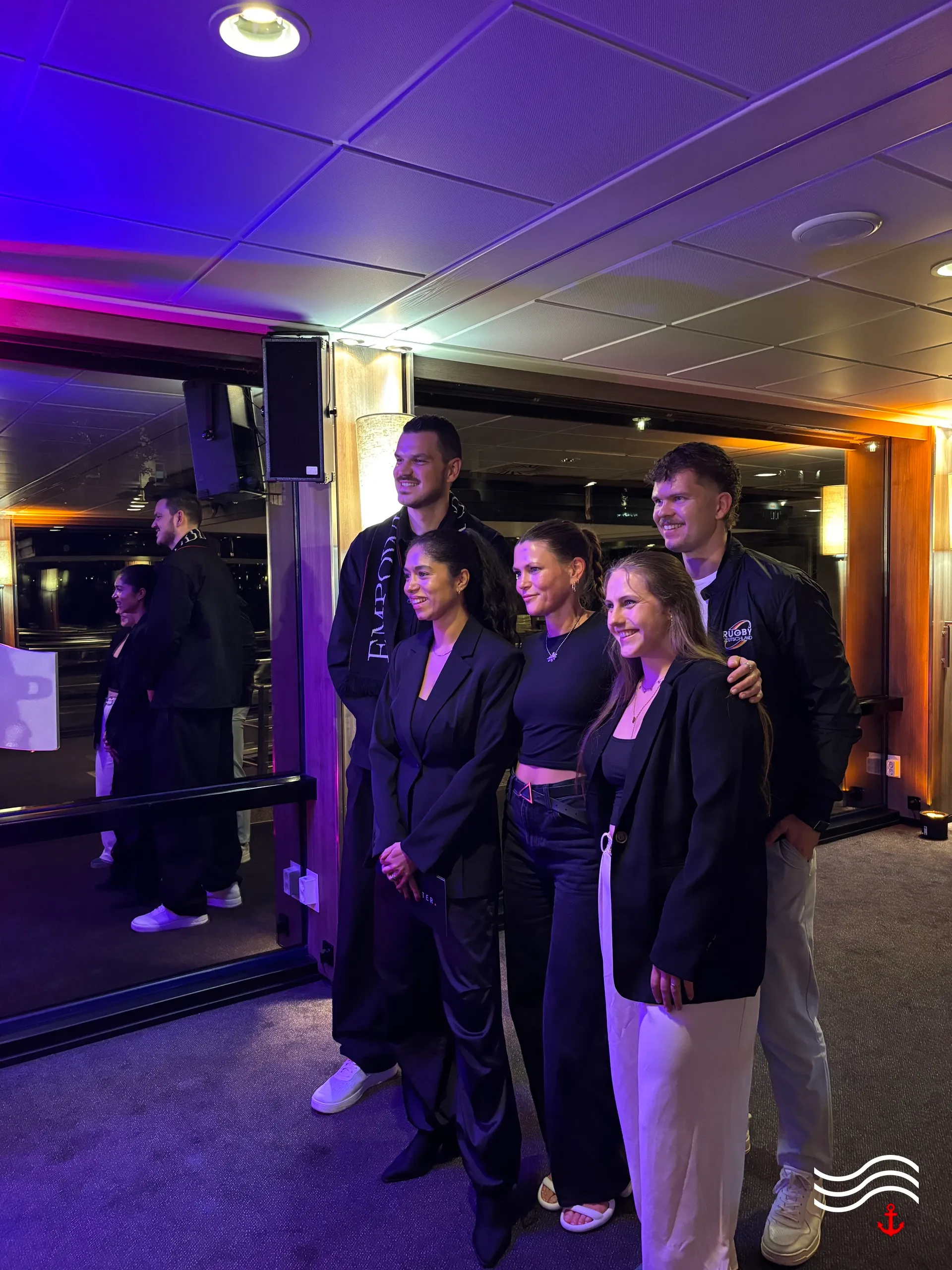 Gruppenfoto von fünf Gästen im violett beleuchteten Salon – brands & agencies THE UPPER DECK 2026 in Köln