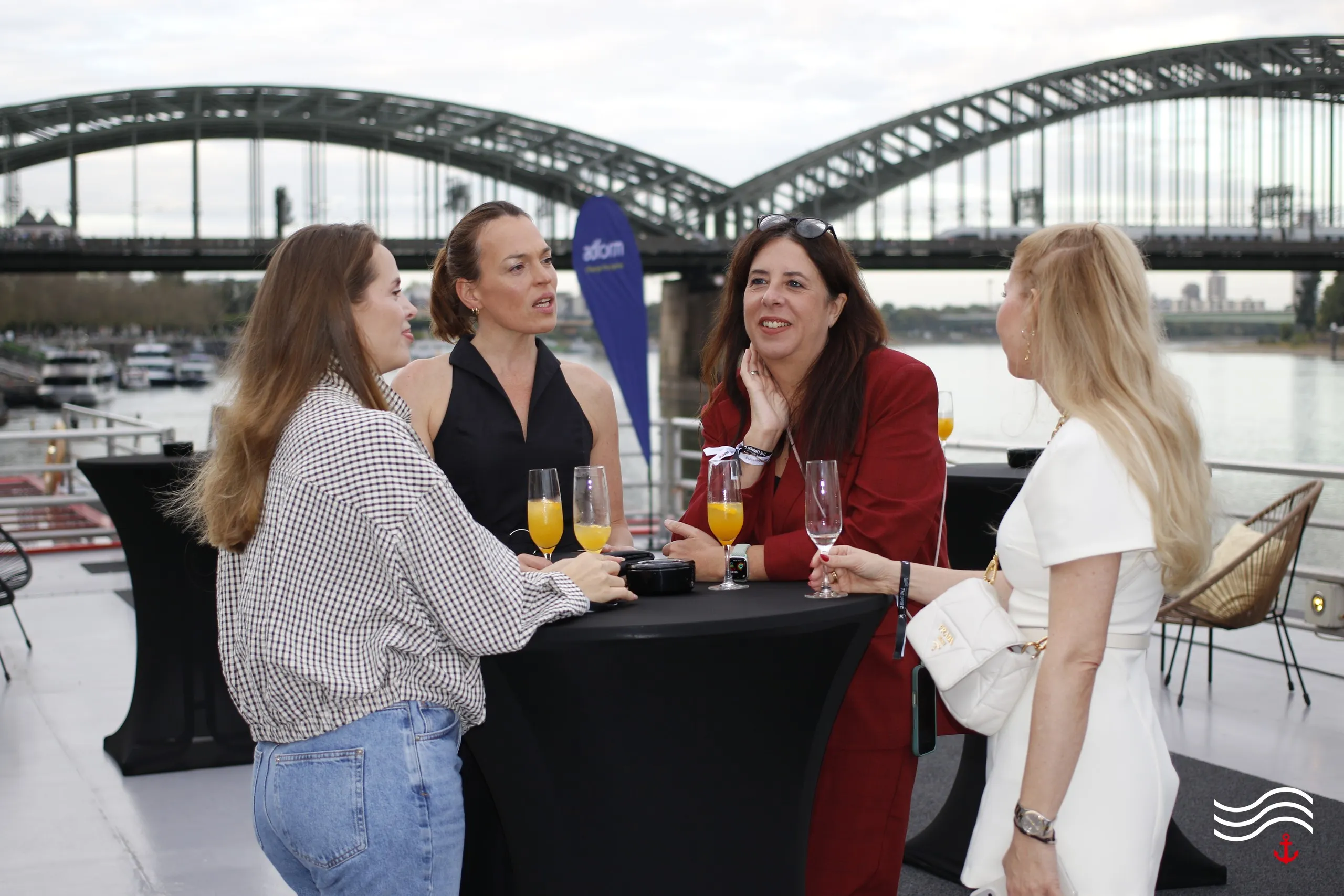 Gäste im Gespräch am Stehtisch an Deck, im Hintergrund die Hohenzollernbrücke – brands & agencies THE UPPER DECK 2026 in Köln