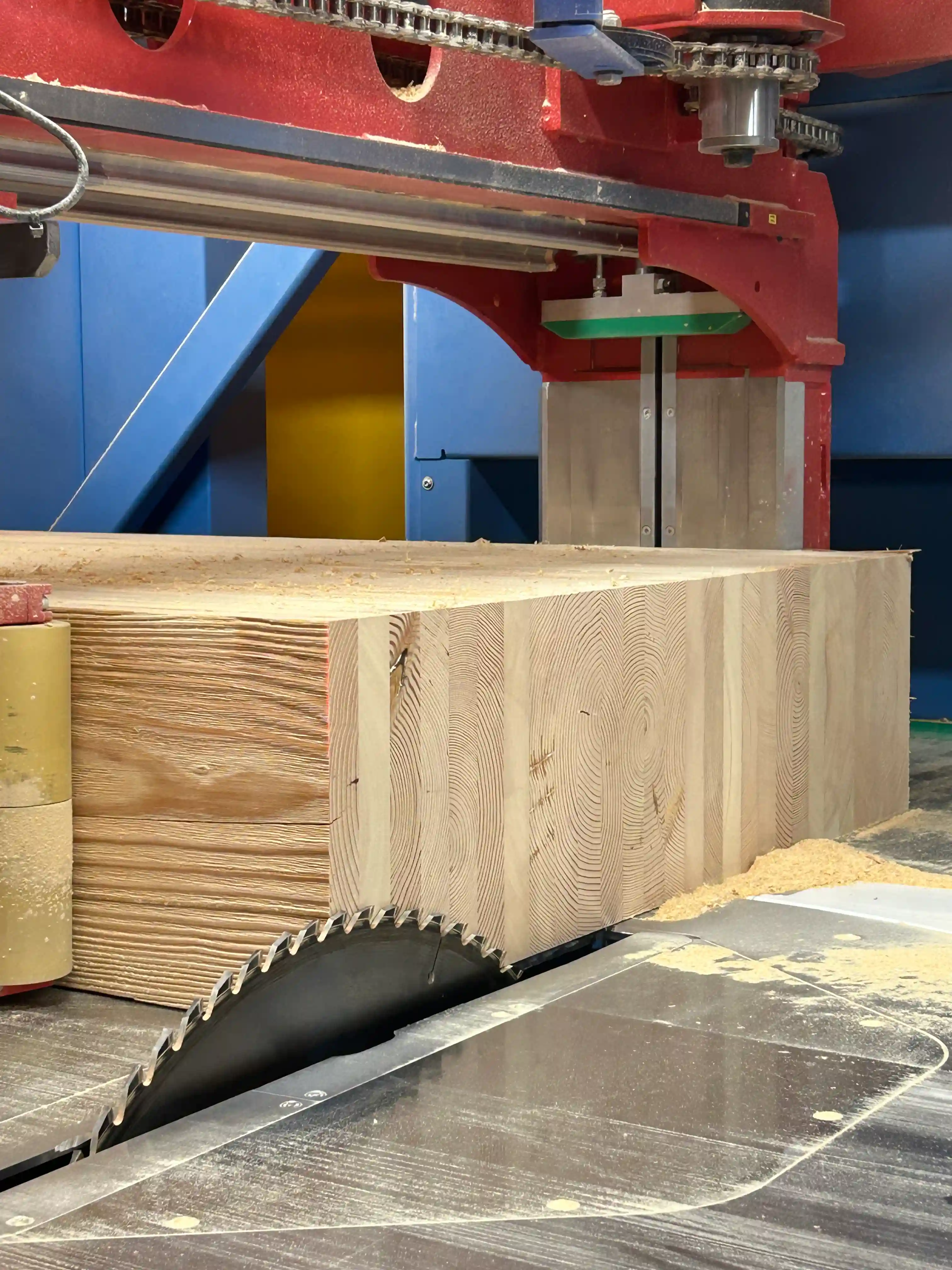 Custom timber frame beams stacked in a pile for production
