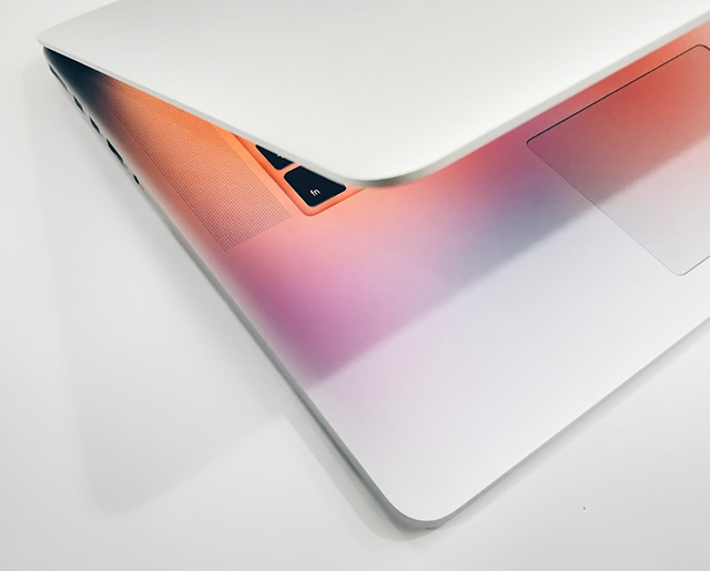 Laptop on a white table that is slightly open