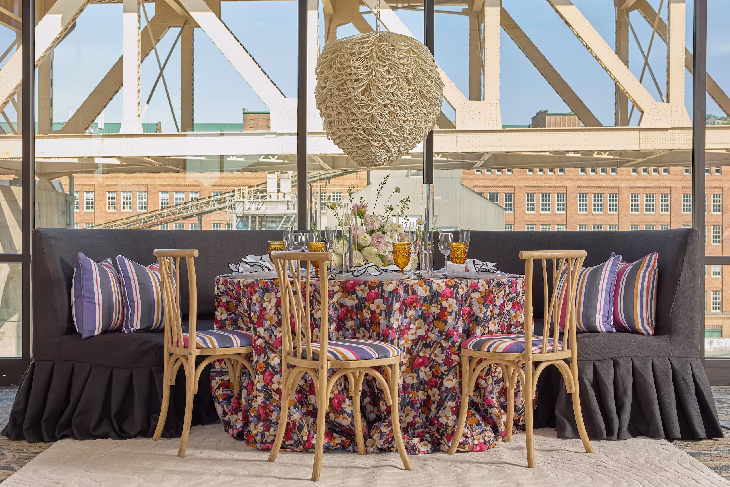 A comfortable and bohemian dining area, framed by a view of a bridge. Photo by Adam Milliron
