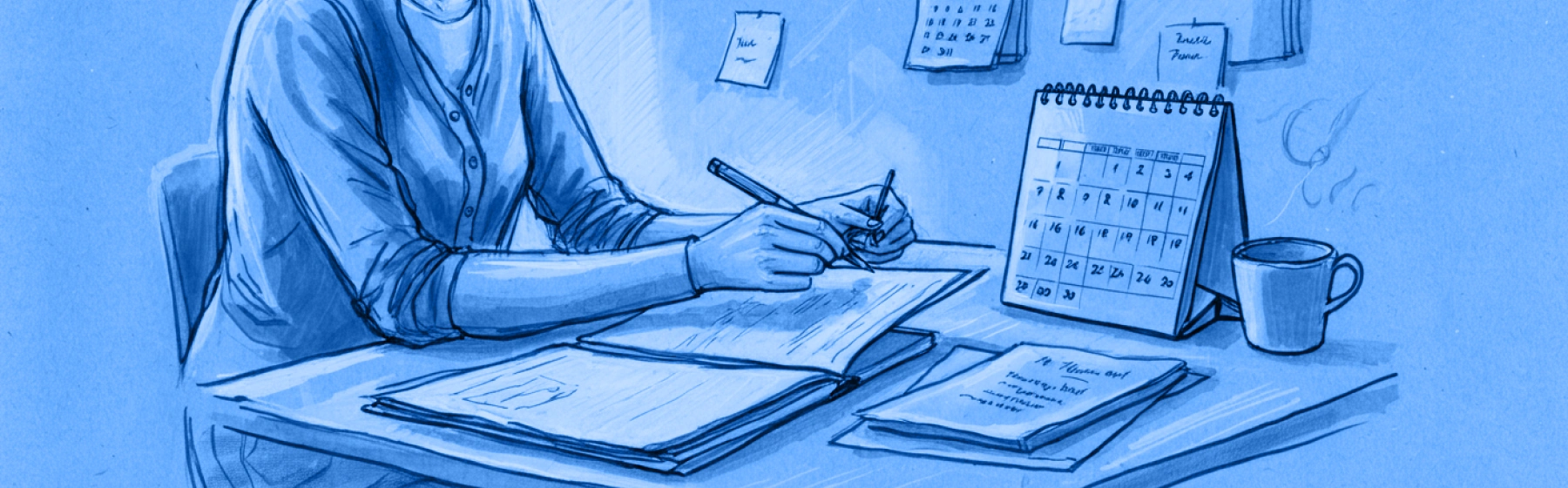 Person writing notes at a desk with a laptop