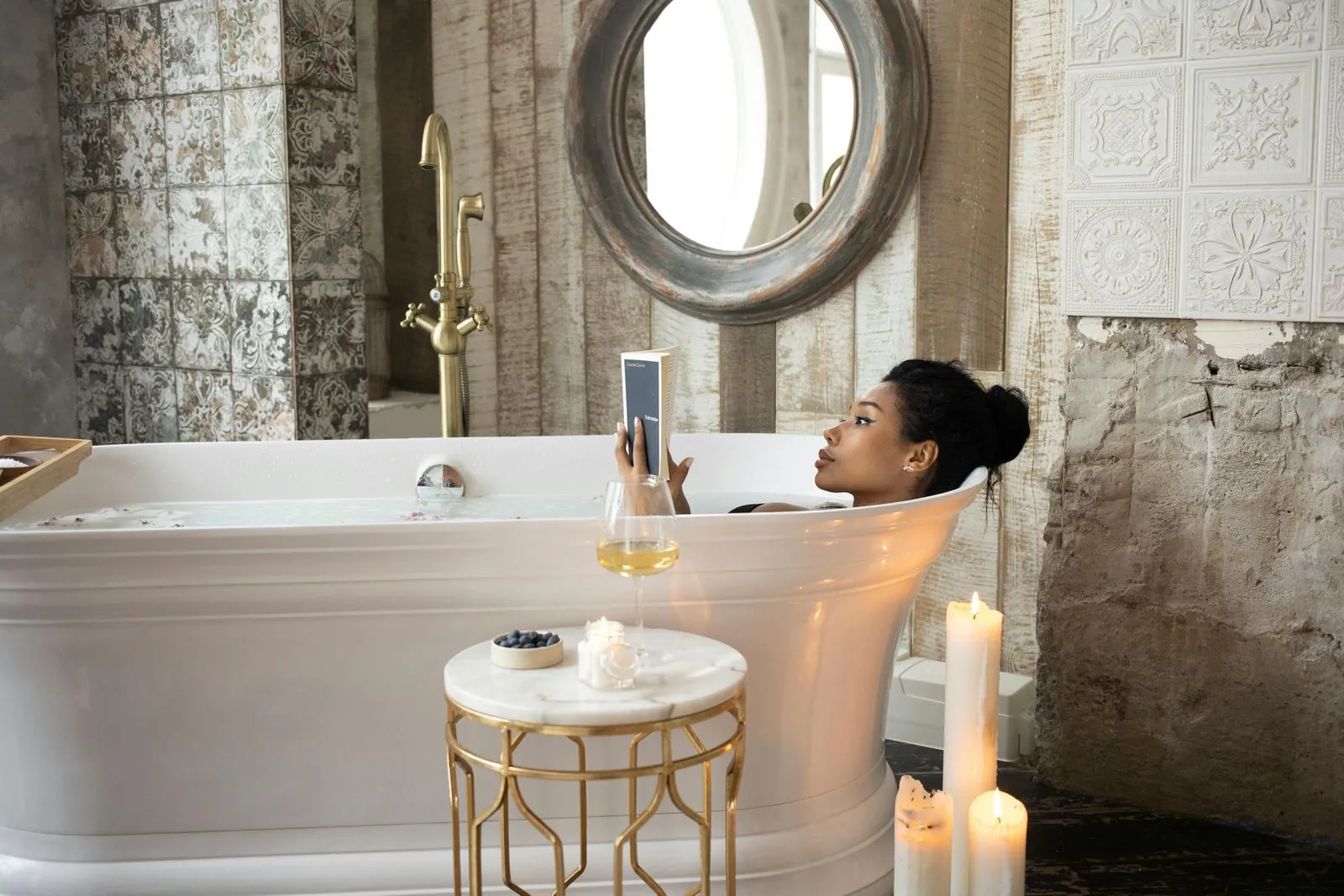 A woman reading a book in a bathtub.