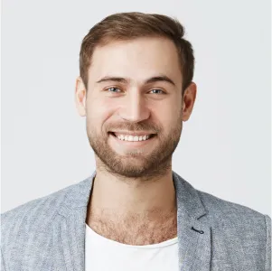 A man with a beard and a gray jacket smiling. - DAS Images