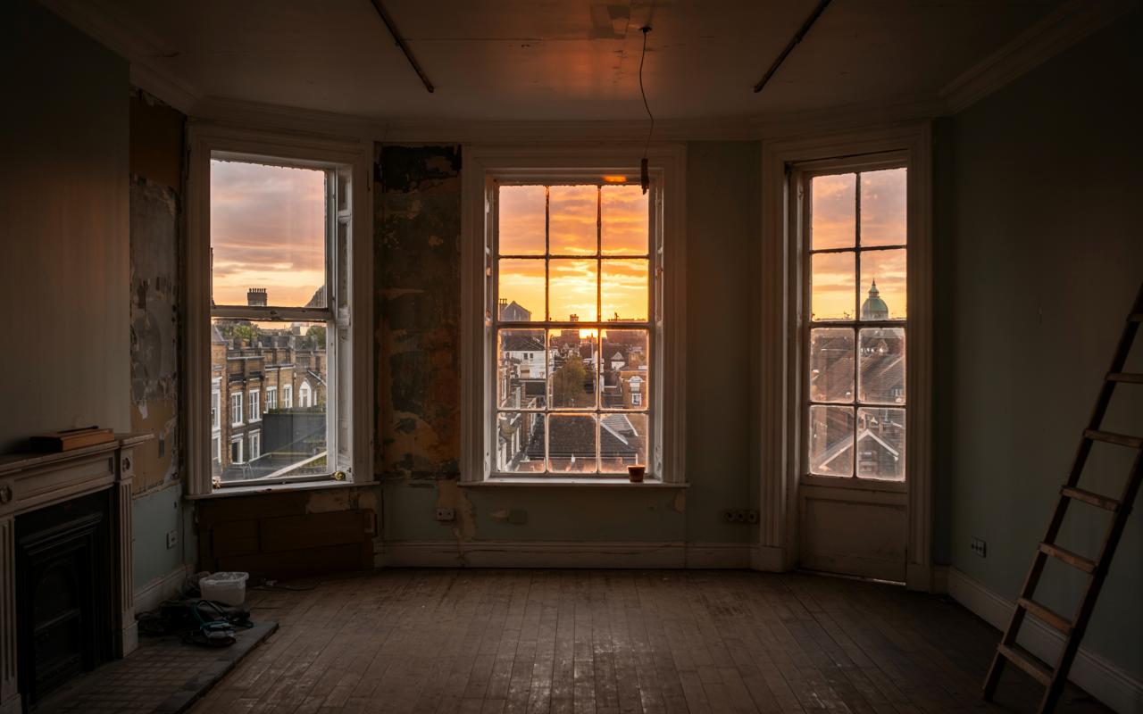 The sun setting outside a window in London. The room is under renovation
