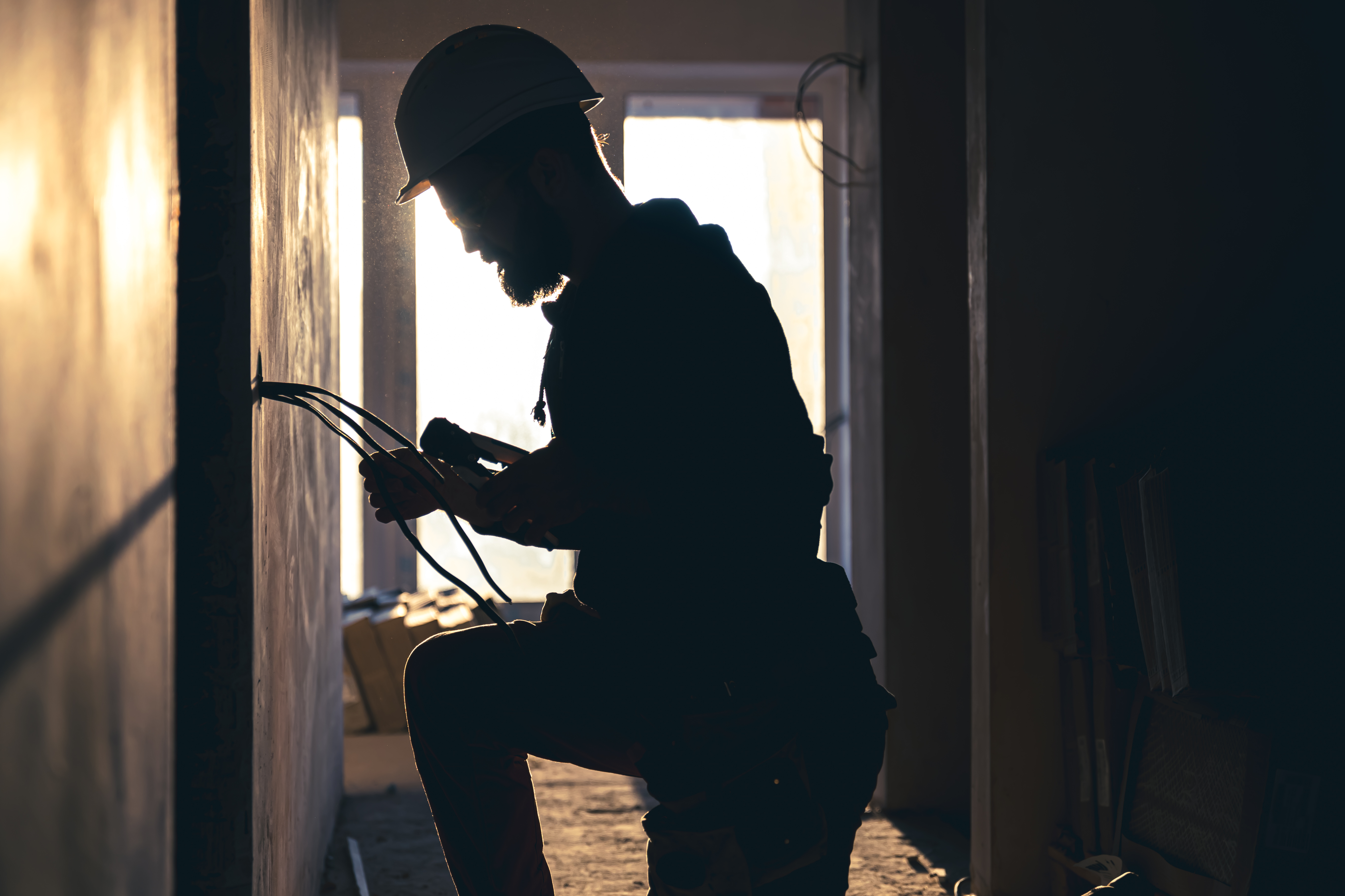 Worker kneeling doing electrical work. 