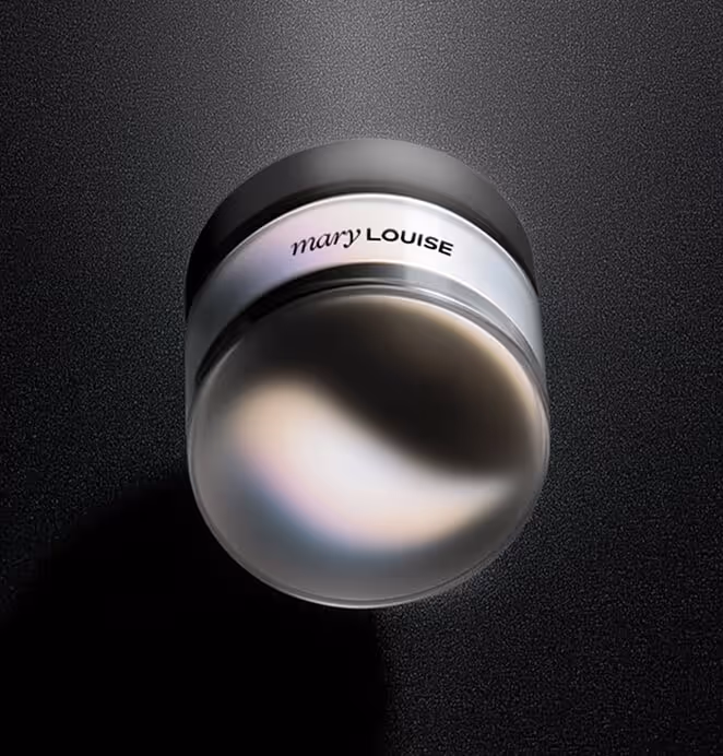 Mary Louise luxury skincare jar with a sleek silver lid and glowing, reflective surface against a textured black background.