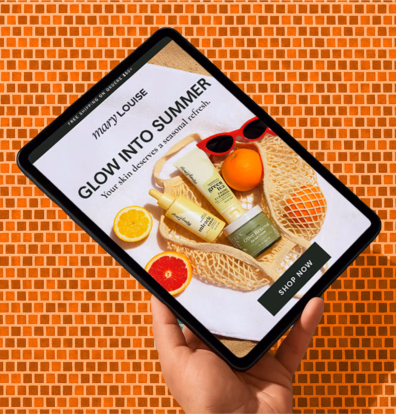 A hand holding a tablet showing a skincare promotion that reads "Glow Into Summer," featuring Mary Louise skincare products with fruits and sunglasses on an orange tiled background.