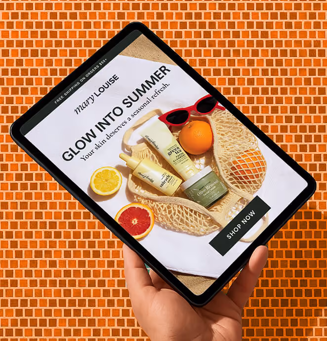Hand holding a tablet with a Mary Louise skincare summer promotion and product photography.