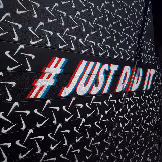 Bold, graffiti-style artwork featuring the slogan "#JUST DID IT" set against a dynamic pattern of iconic swoosh symbols, suggesting powerful branding and action-oriented messaging.