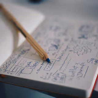 Open notebook filled with detailed pencil sketches, doodles, and preliminary design concepts, highlighting creative brainstorming and idea exploration.