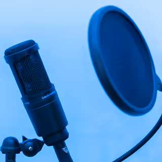 Close-up of a studio microphone and pop filter against a blue wall, suggesting podcasting, voice recording, or audio branding.