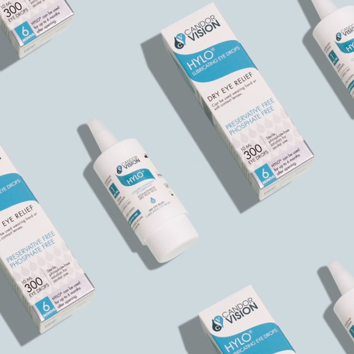A flat-lay product shot featuring HYLO lubricating eye drops by Candor Vision, with clean blue-and-white packaging highlighting preservative-free dry eye relief.