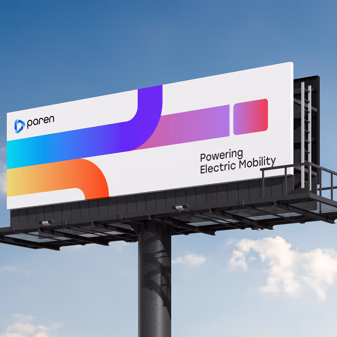 A modern billboard with gradient purple, pink, and orange graphics and the tagline “Powering Electric Mobility” by Paren.
