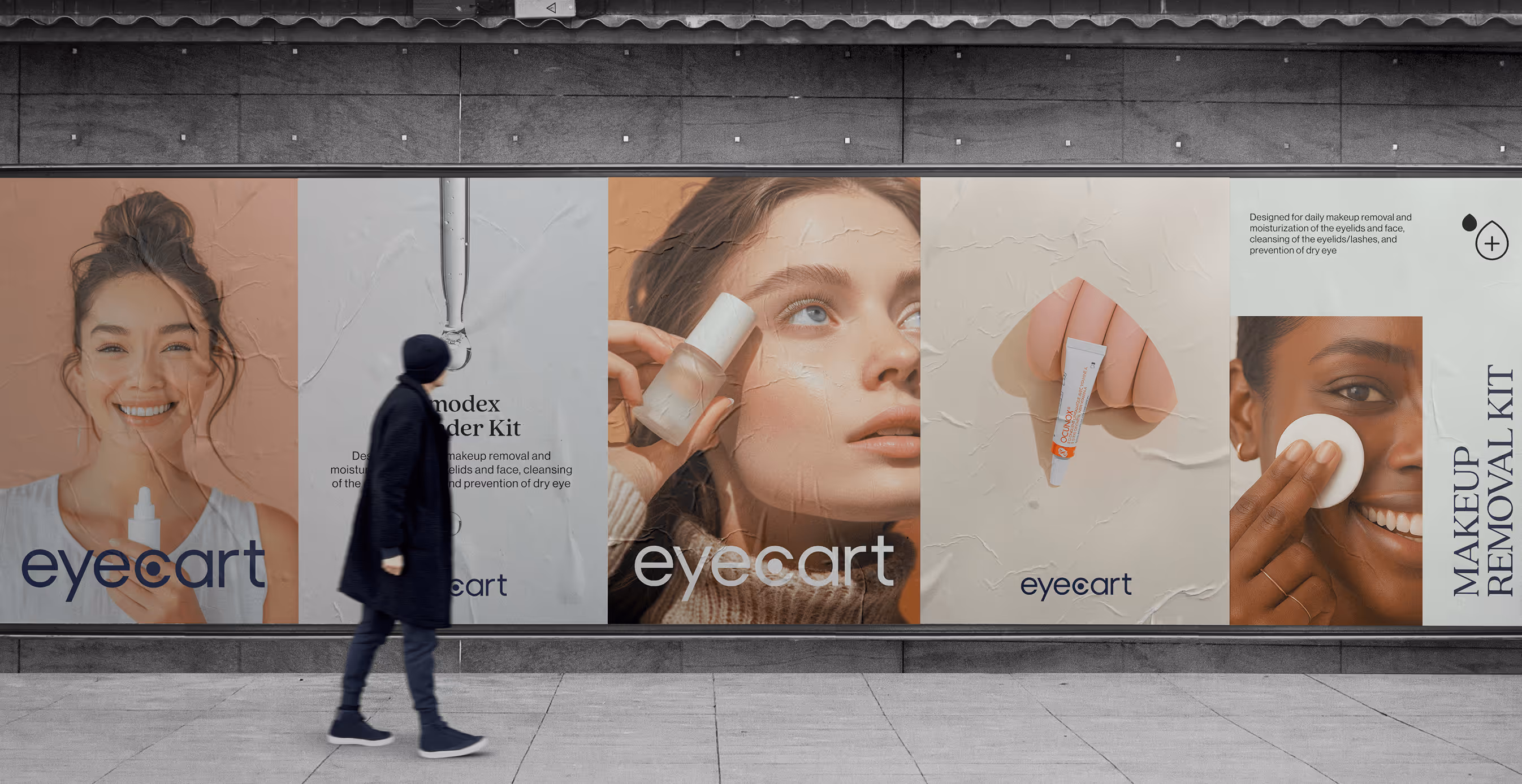 Large outdoor posters for Eyecart showcase skincare and eye care products. Smiling models hold bottles and apply products, paired with clean typography and soft, neutral backgrounds. A passerby walks in front of the display.